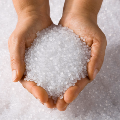 A handful of virgin thermoplastic resin pellets, the raw material for every moulded part